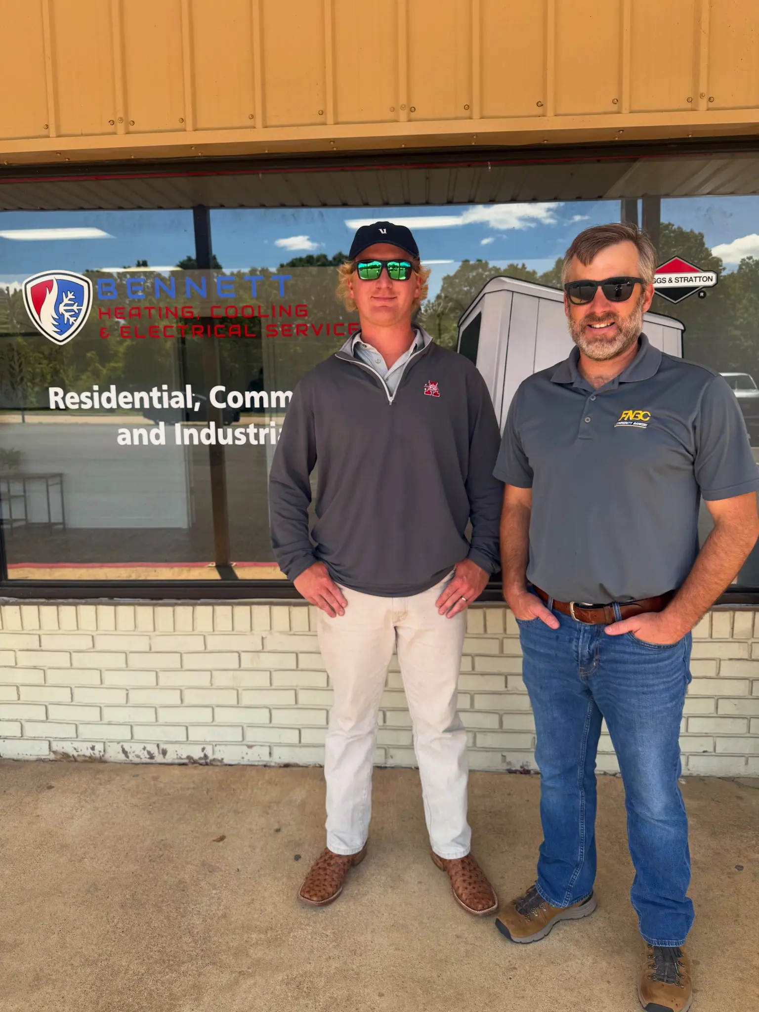 Two men outside HVAC company storefront
