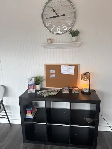Wall clock above black shelf with decor